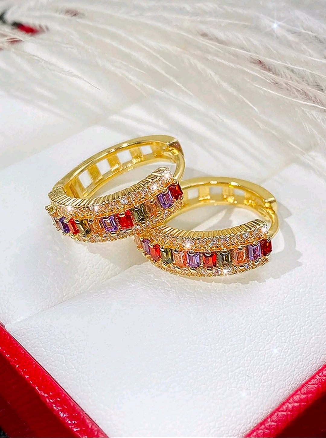 Estas argollas de diseño arcoíris son un accesorio moderno de estilo huggie, caracterizadas por su acabado brillante y su llamativa combinación de colores.