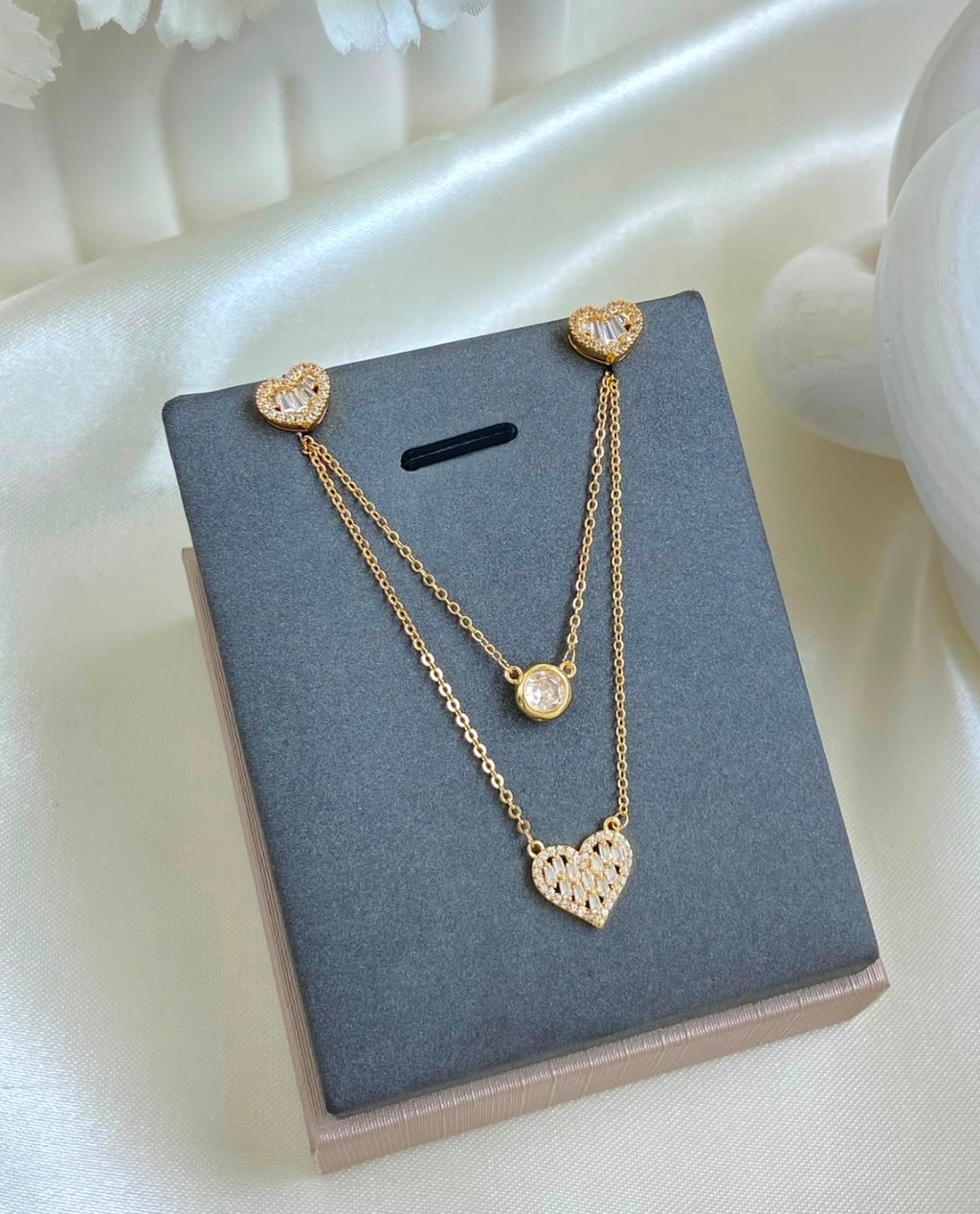 Variedades de elegante juego de cadenas y aretes con baño de oro.