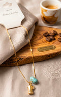Hermosa cadena con medalla de greca y larimar con baño de oro.