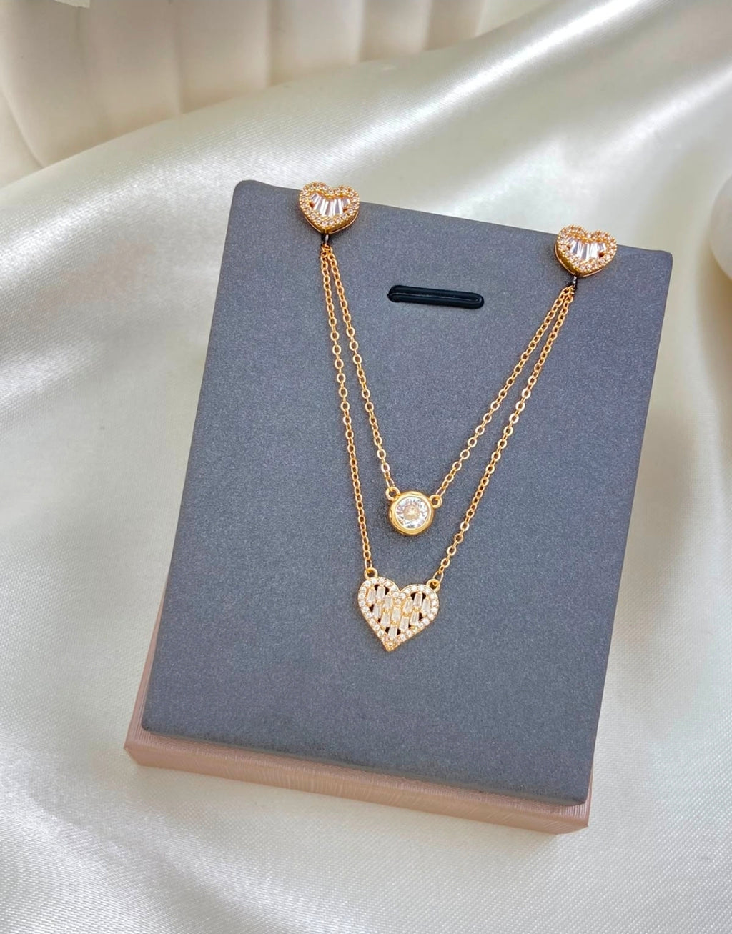 Variedades de elegante juego de cadenas y aretes con baño de oro.