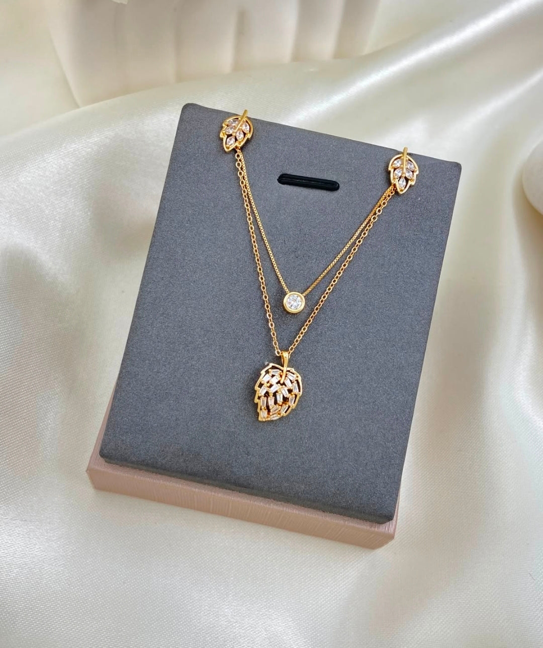 Variedades de elegante juego de cadenas y aretes con baño de oro.